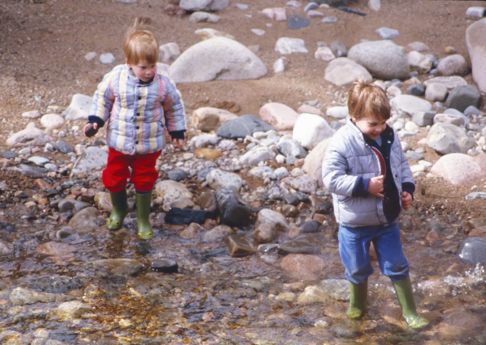 charles, princes of wales, prince william, and prince harry play by the river dee, in scotland