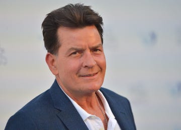 charlie sheen looking to his right and smiling for a photo