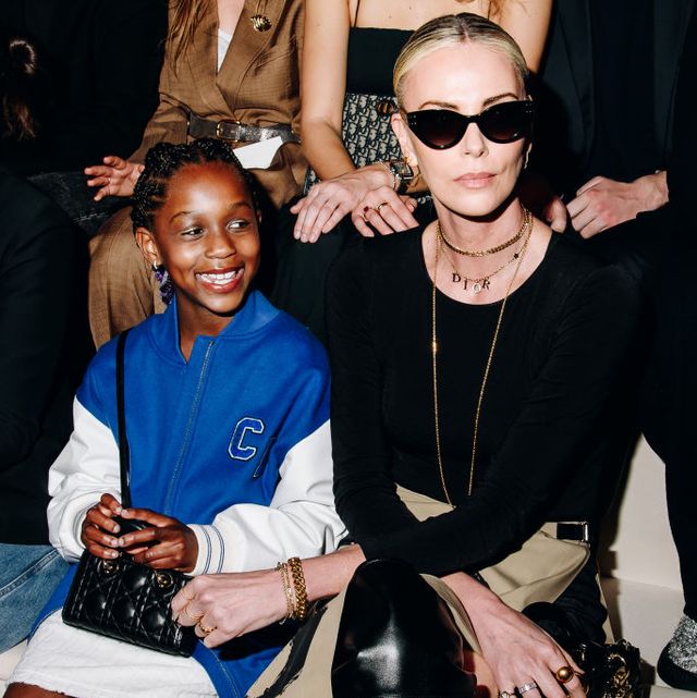 charlize theron and her daughter august theron at the dior pre fall 2024 charlize is dressed in black and nude colours while her daughter is wearing a bright blue and white baseball jacket