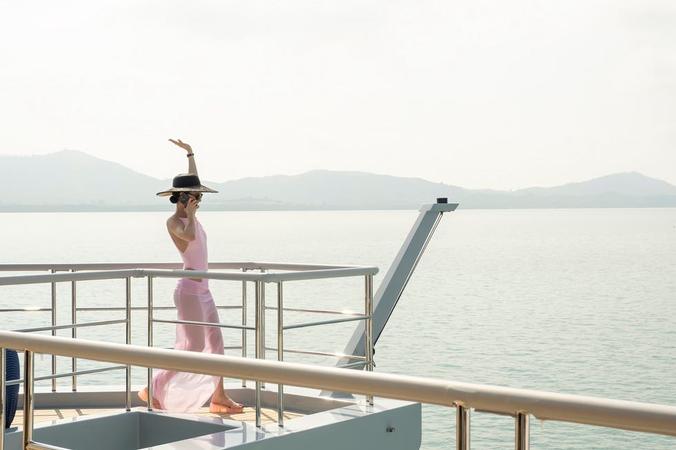 woman walking with her hand in the air while on a yacht
