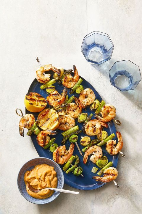 charred shrimp, leek and asparagus skewers on blue plate