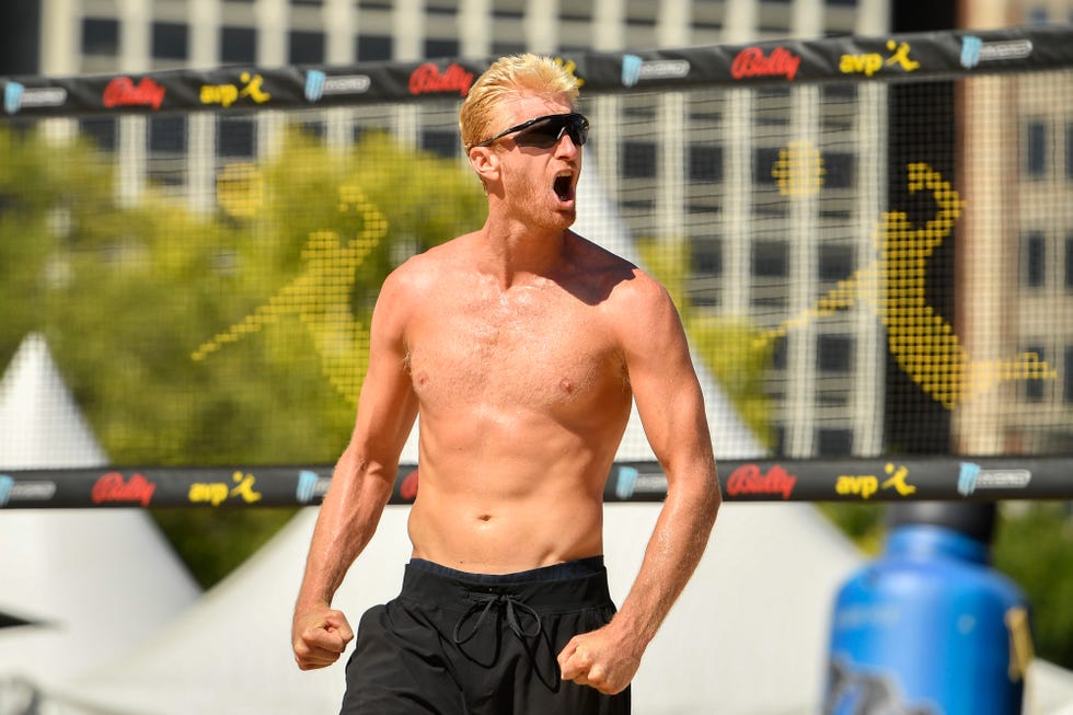 chase budinger wearing sunglasses and celebrating with a beach volleyball net in the background