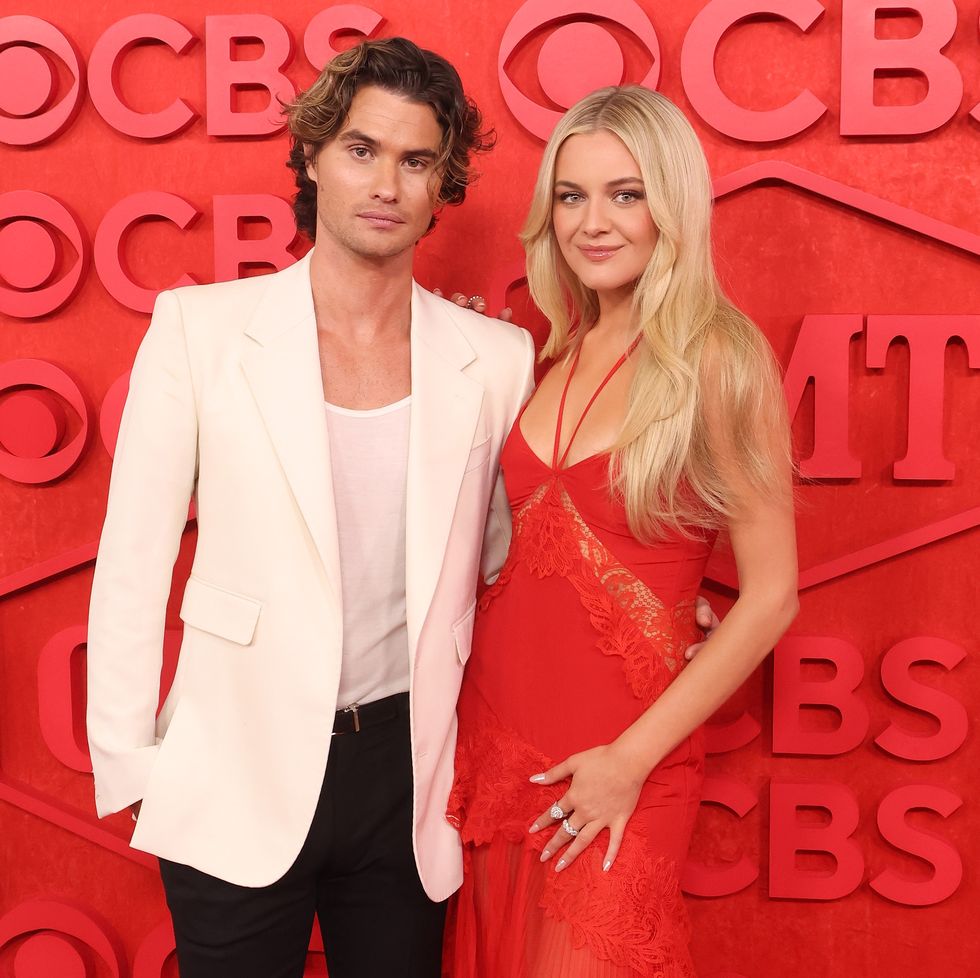 chase stokes and kelsea ballerini embracing and posing for a photo in front of the cmt music awards background