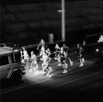 Adidas Chasing100 group of runners participating in a nighttime race alongside a vehicle