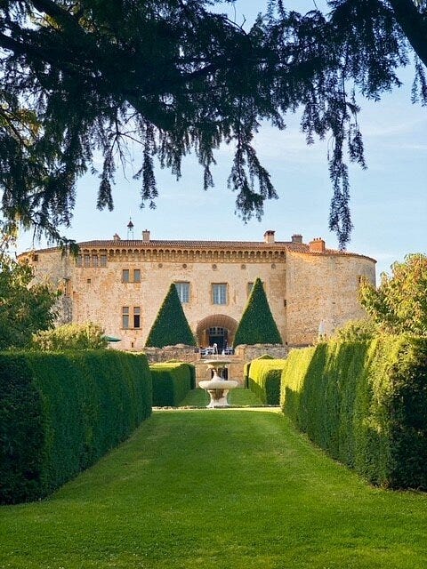 historic castle with manicured gardens and a fountain