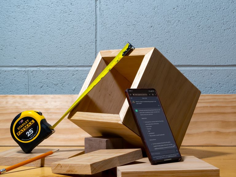 a tape measure spread across a wooden box with a phone displaying the chatgpt dashboard
