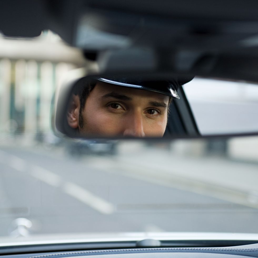 chauffeur looking in rear view mirror