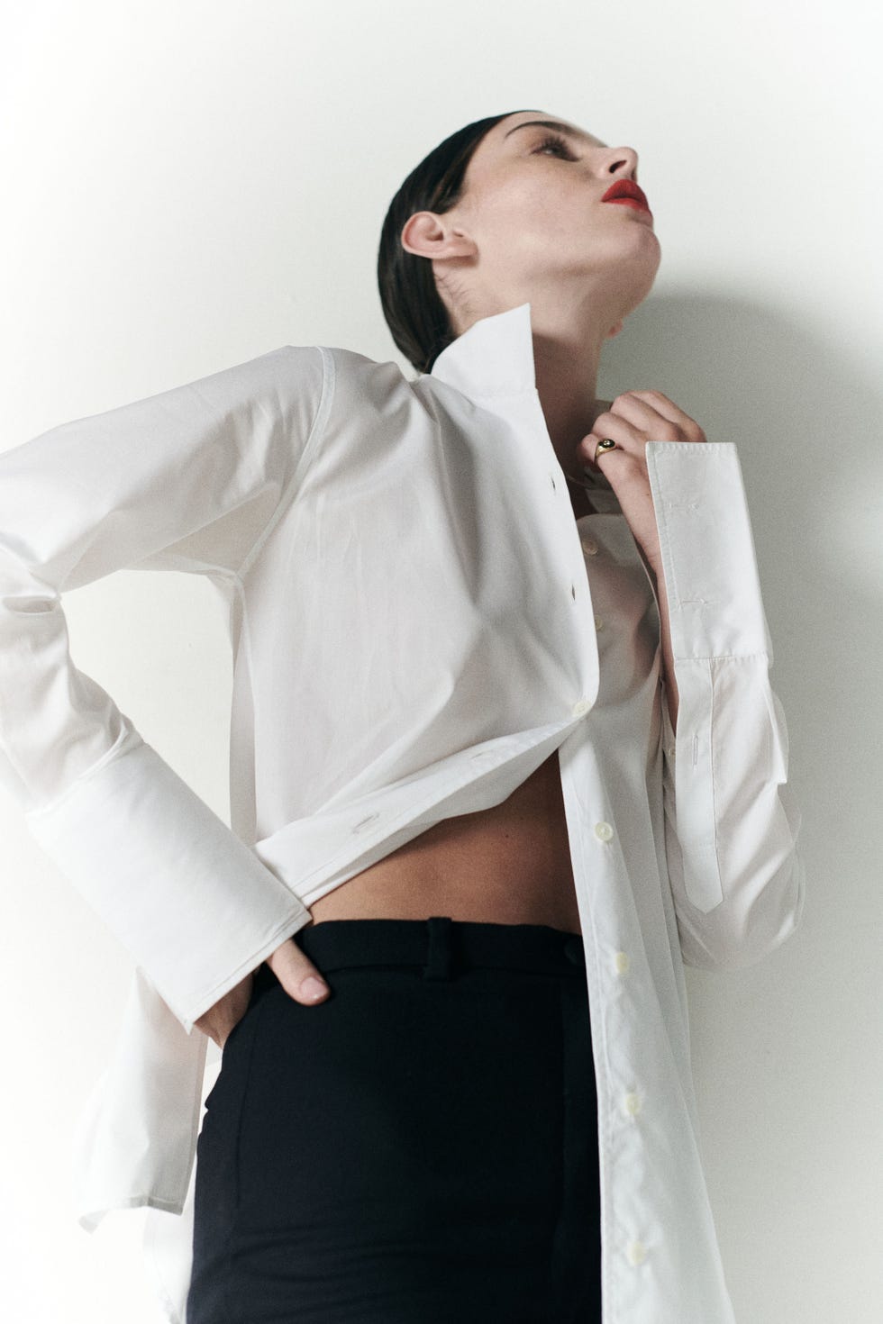 a person wearing a white shirt and black pants posing with a stylish posture