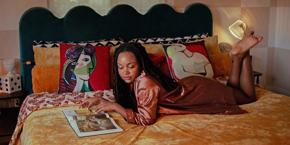 girl laying on bed reading a book