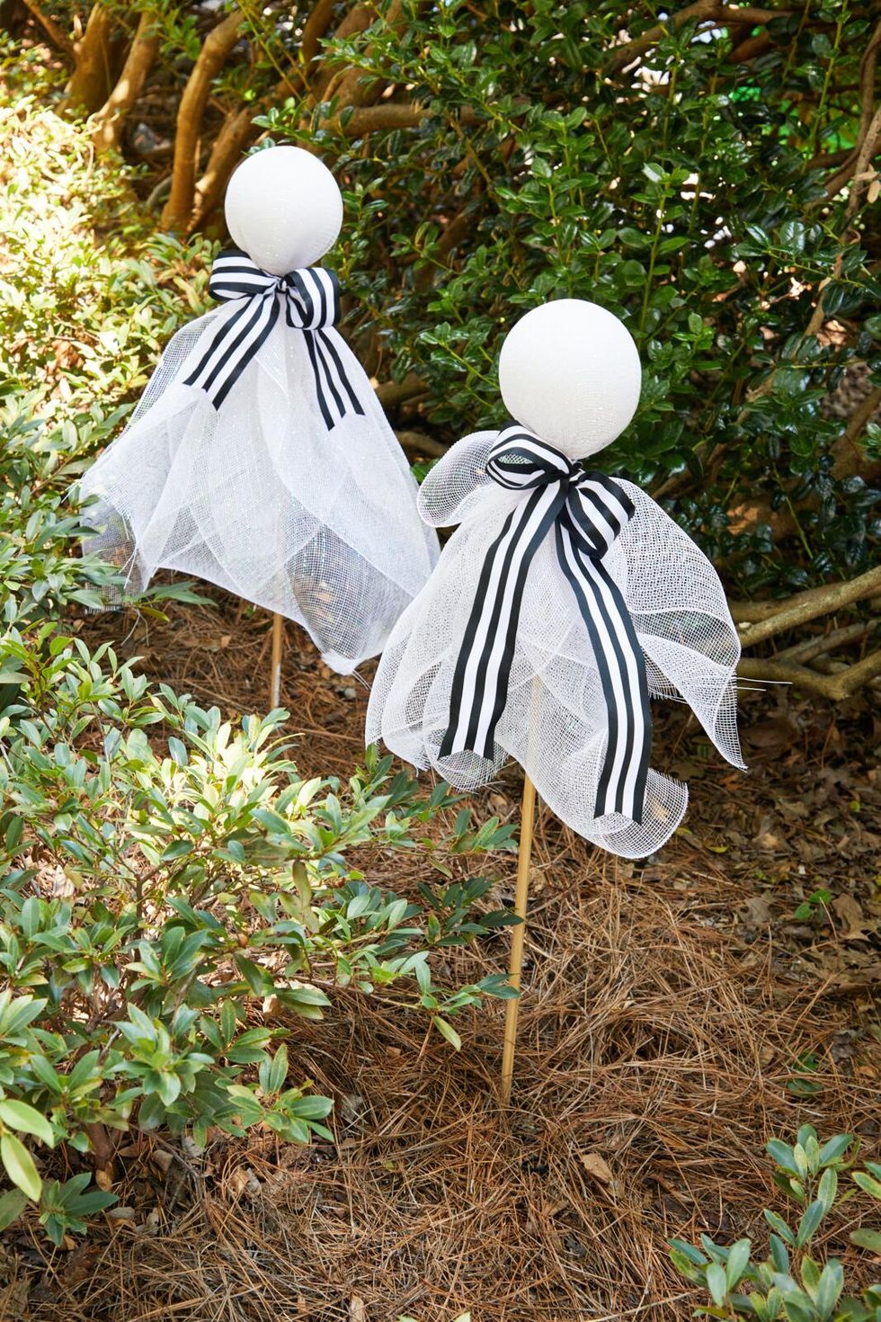 styrofoam balls with stakes intserted in the bottom wrapped in large glittery ribbon to look like ghosts