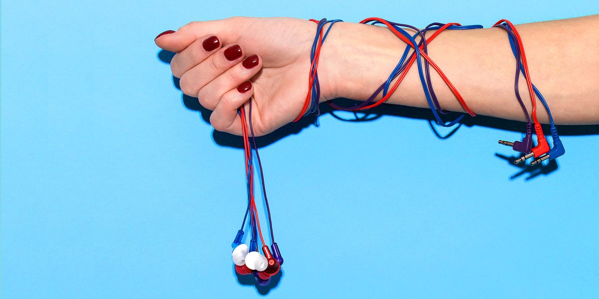 woman with red nail polish holding three colorful cheap earbuds