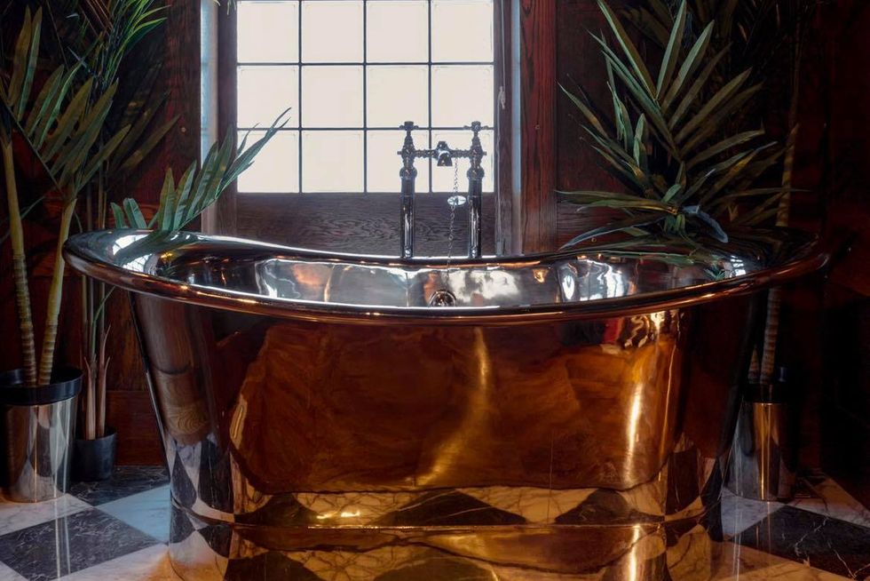 a freelancing copper bath surrounded by plants