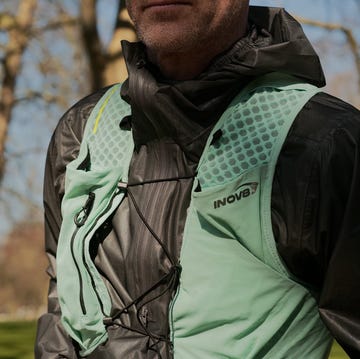 close up of a faceless man wearing a green running vest and grey raincoat close up of a faceless man wearing a green running vest and grey raincoat