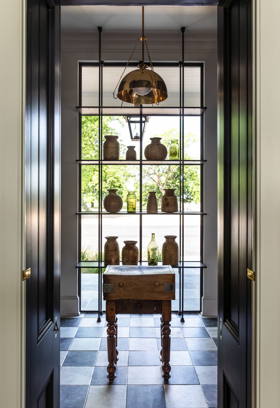 entrance area featuring a decorative shelf with various jars and a wooden table