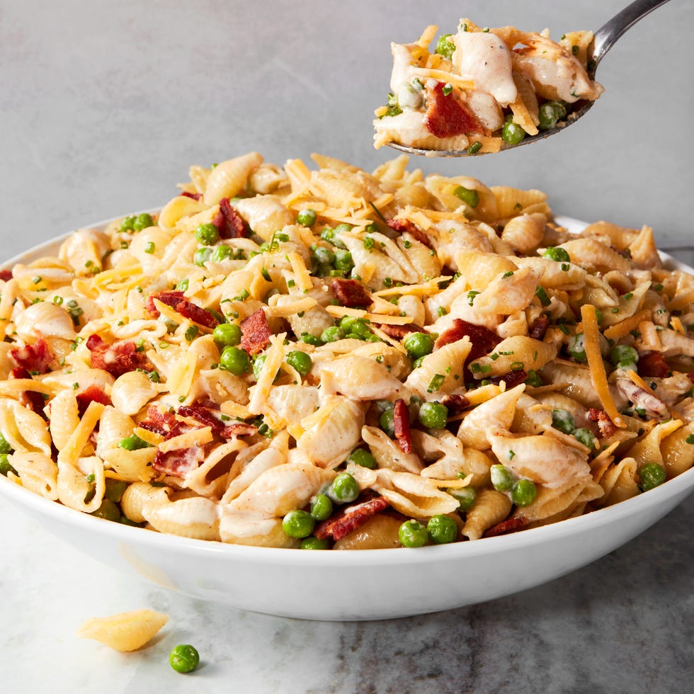 pasta noodles tossed with bacon, peas, and cheddar cheese all tossed in a creamy sauce
