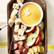 Cheddar-Beer Fondue with bread cubes, sausage, potatoes and apples cheddarbeer fondue with bread cubes, sausage, potatoes and apples