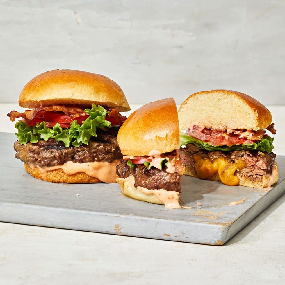 cheddar stuffed cheeseburgers on a wooden board