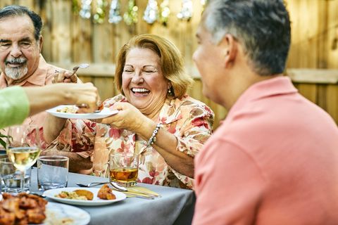 cheerful family eating at table in back yard