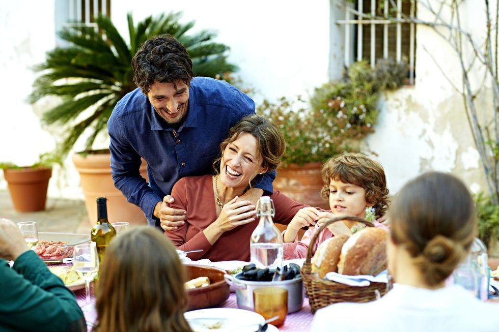 cheerful family enjoying at outdoor meal table