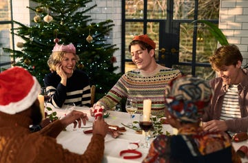 cheerful family sitting down after christmas dinner playing games