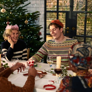 Cheerful family sitting down after Christmas dinner playing games cheerful family sitting down after christmas dinner playing games