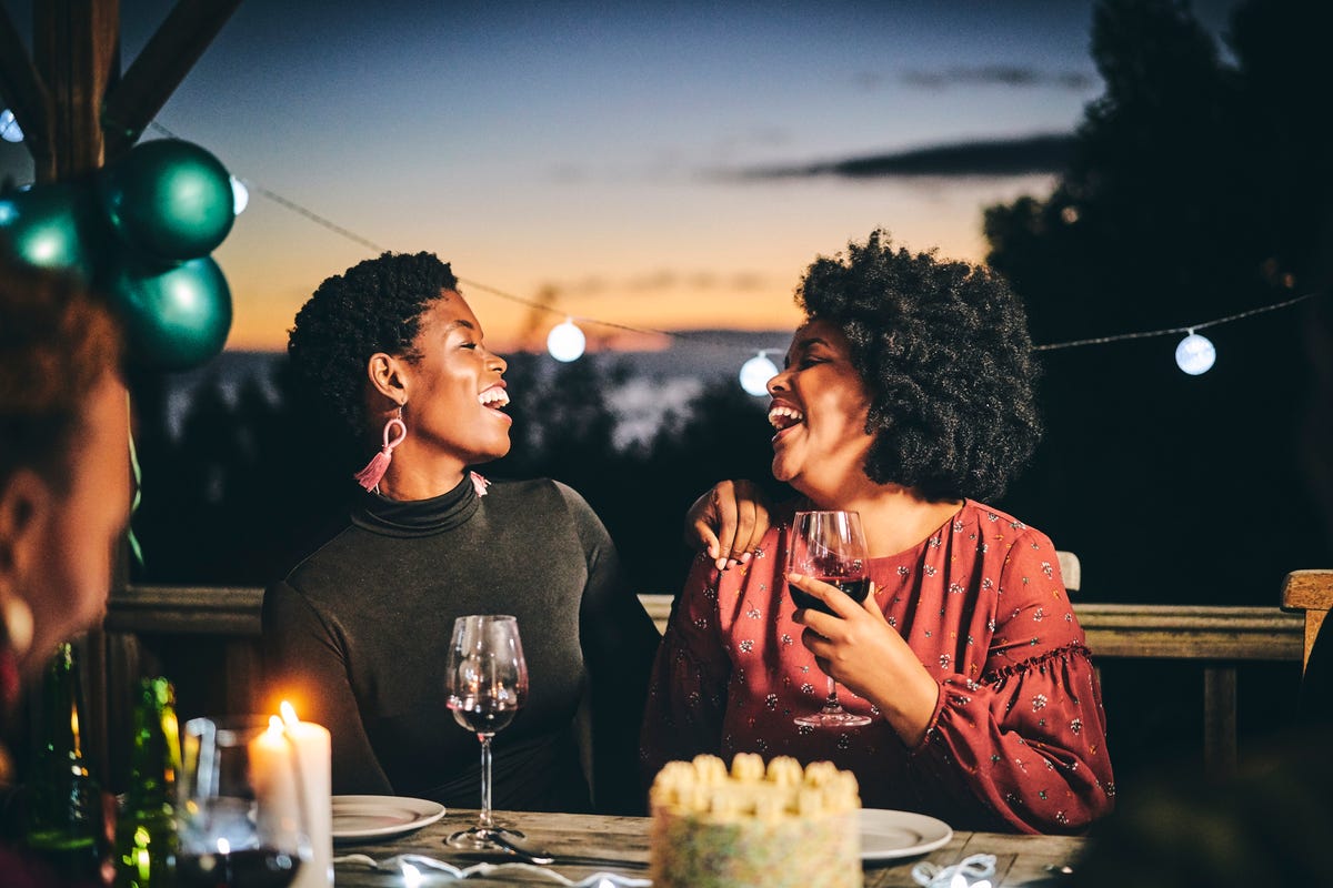 cheerful female friends enjoying wine at birthday