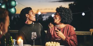cheerful female friends enjoying wine at birthday
