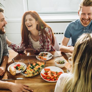 cheerful friends communicating while enjoying in a meal at dining table