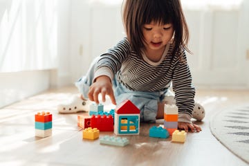 girl playing toy blocks in living room at home