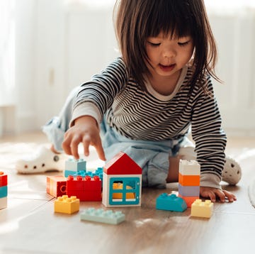 Fun Indoor Activities for Kids girl playing toy blocks in living room at home