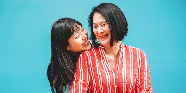 Cheerful Mother And Daughter Against Blue Background