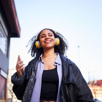 cheerful woman listening to music with a mobile outdoors