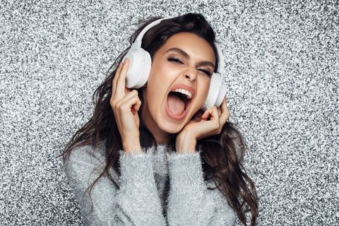 new years colors woman wearing silver sweater and listening to music through headphones