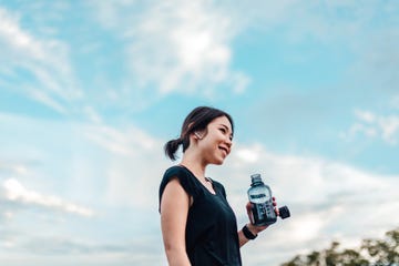 cheerful young woman with water bottle after exercising