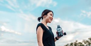 cheerful young woman with water bottle after exercising