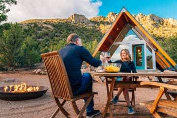 couple sharing a toast with a tiny home in the background