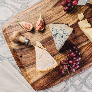 cheese figs and grapes on wooden cheese board