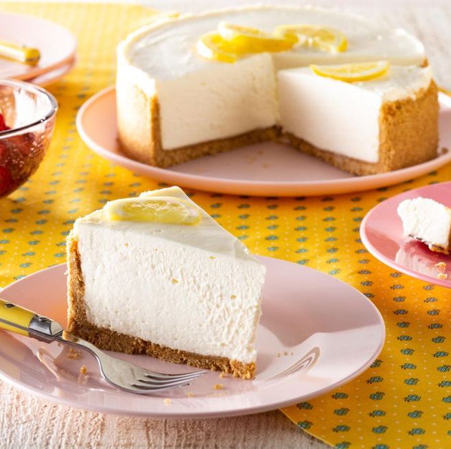 no bake lemon cheesecake slice on plate in front with bowl of fruit