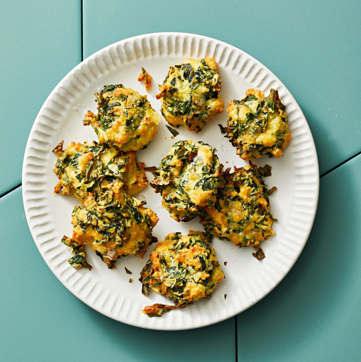 cheesy kale nests on a blue tile background