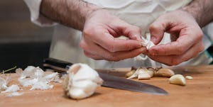 Chef adding peeling garlic