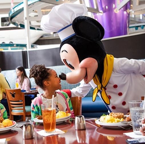 a family eating with mickey mouse at chef mickey at walt disney world