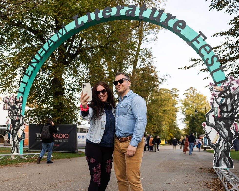 a man and woman posing in front of a large arch