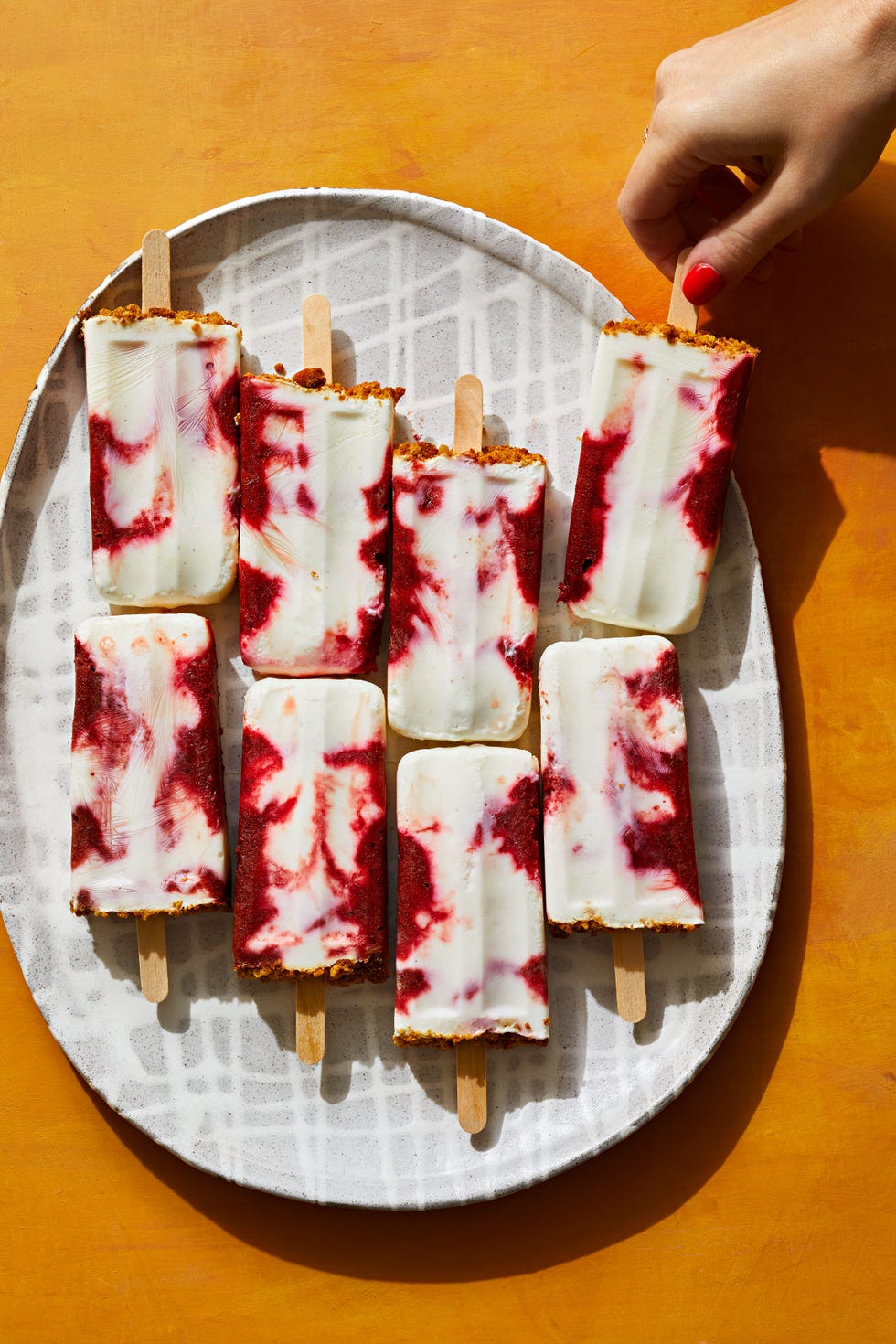 cherry froyo pops on a grey and white plate