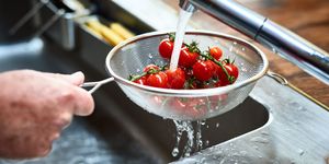 Cherry vine tomatoes being washed in sieve