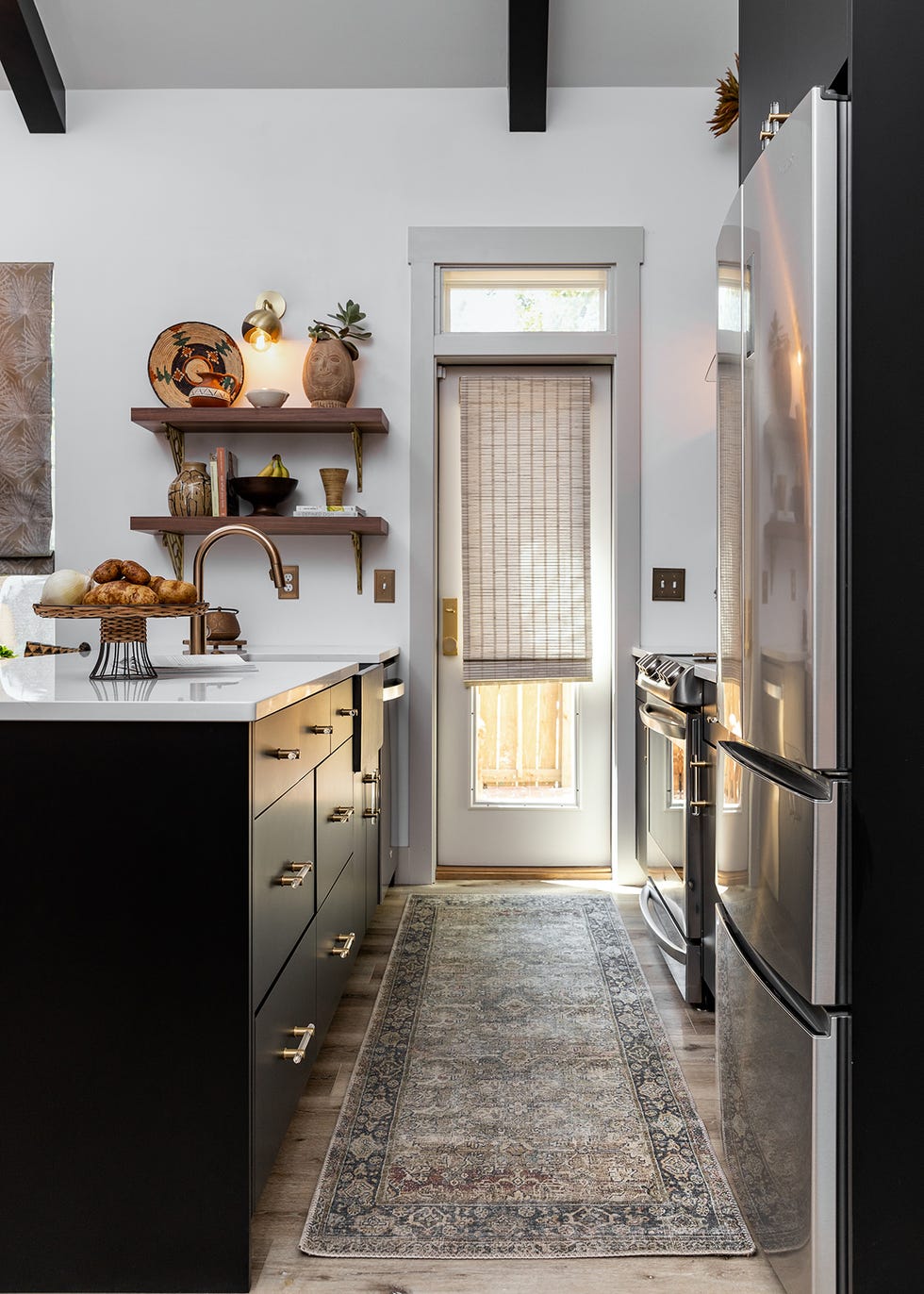 galley kitchen with black cabinets and runner