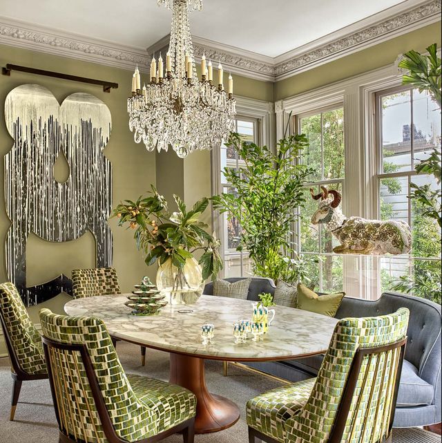 Green chairs around marble table with blue banquette