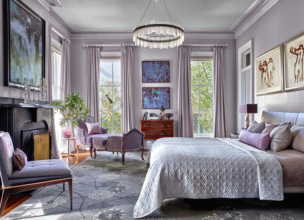 Muted lilacs and grays on the headboard, coverlet, walls, rug, and seating