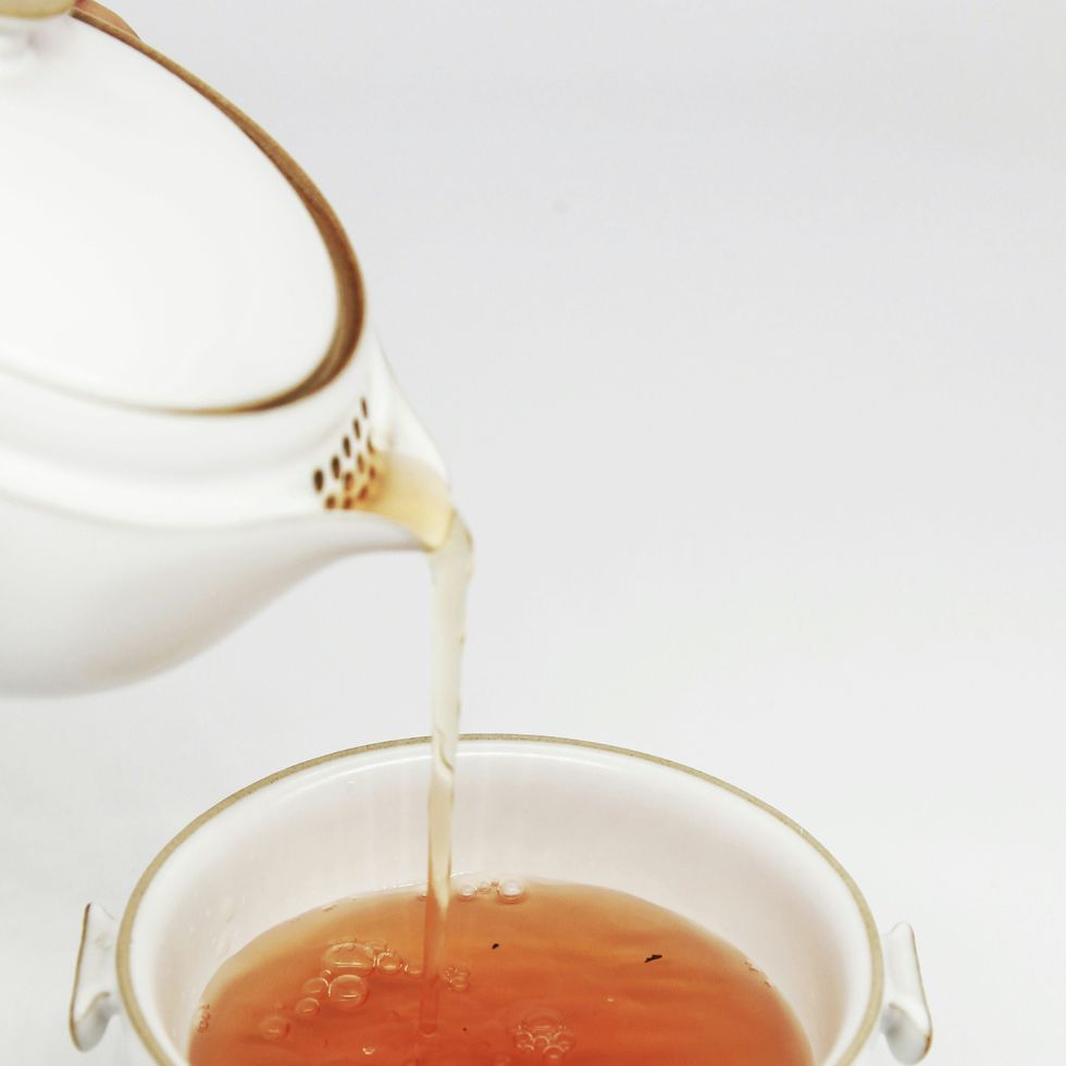 a teapot pouring tea into a cup