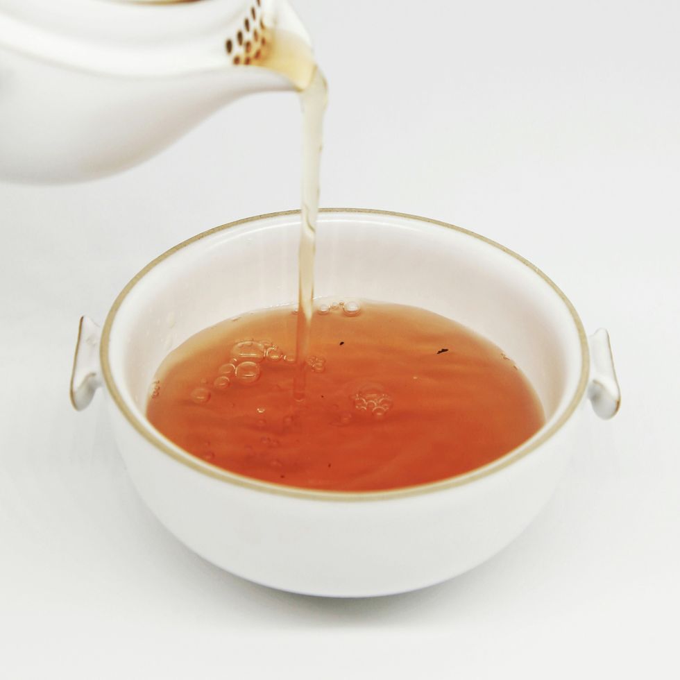 a teapot pouring tea into a cup