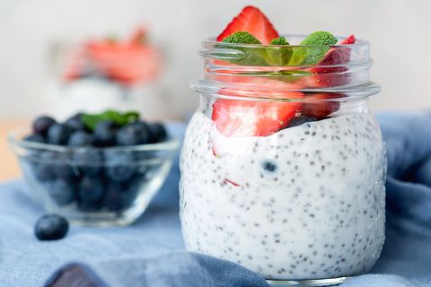 Chia pudding in jar with strawberries, blueberries and mint